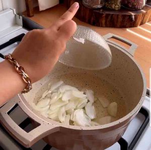 Frying onions to prepare eshkeneh