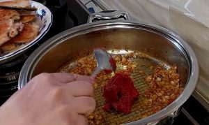 fry tomato paste with onions