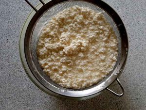 Pour the mixture of milk and curdled yogurt into the colander